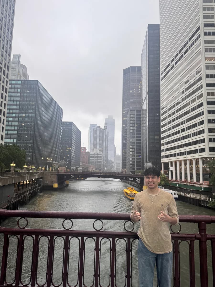 Alex by the Chicago River with the city skyline behind him
